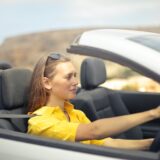 woman in yellow shirt driving a silver car